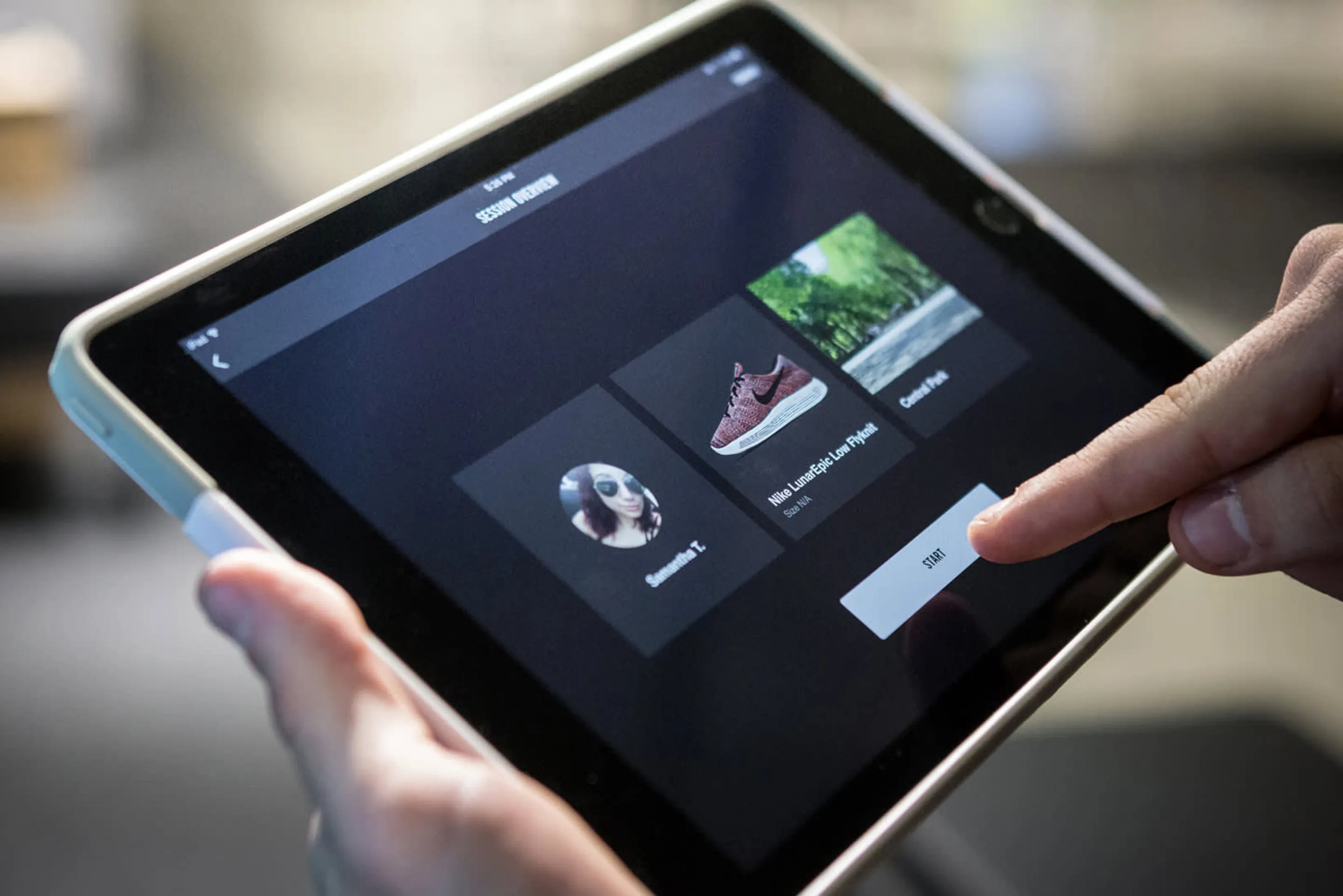 A Nike store employee holding the Nike Trial Zone iPad Controller developed by Everyday Odyssey for AKQA which is used to direct consumers through the immersive interactive in-store game experiences